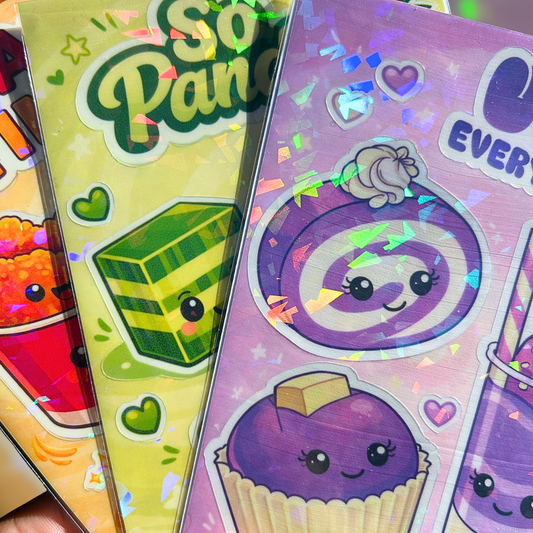 Close up image of three colorful sticker sheets held by a hand with a blurred background