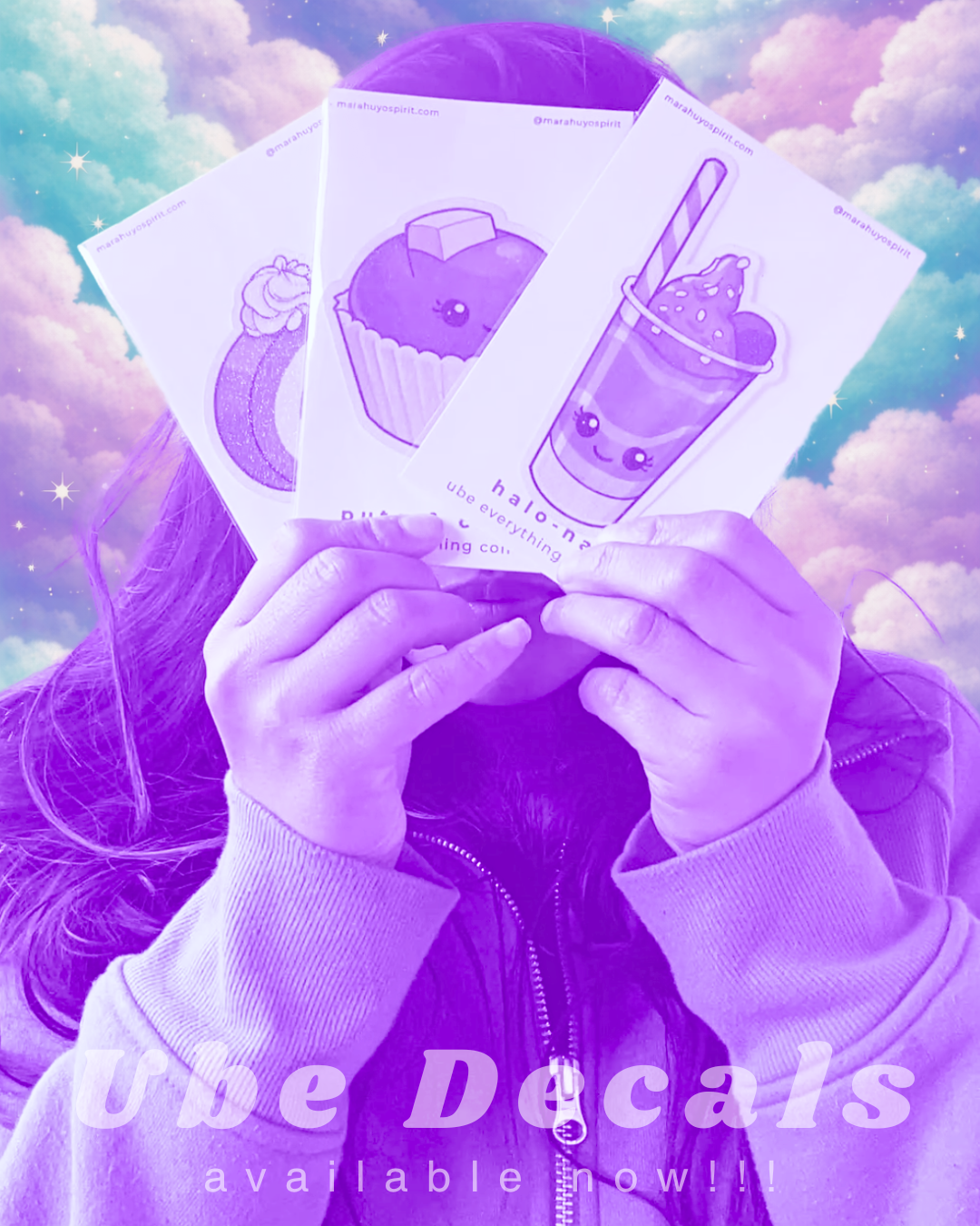 Hands holding ube-themed decals against a pastel, cloud-filled sky.