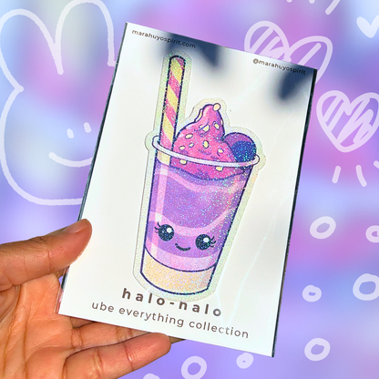 Hand holding a card with a cute ube halo-halo glitter die-cut decal and 'halo-halo' branding on a colorful background.